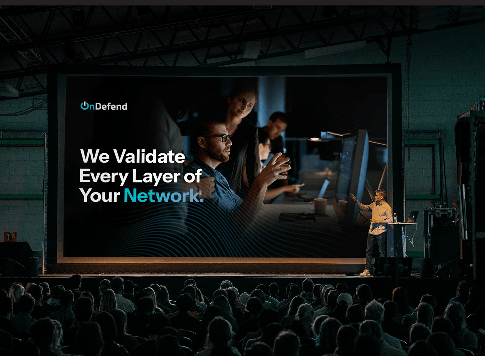OnDefend's We Validate Every Layer of Your Network campaign displayed on a conference stage